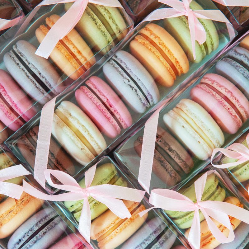 French Macarons pictured in a gift box tied with ribbon.